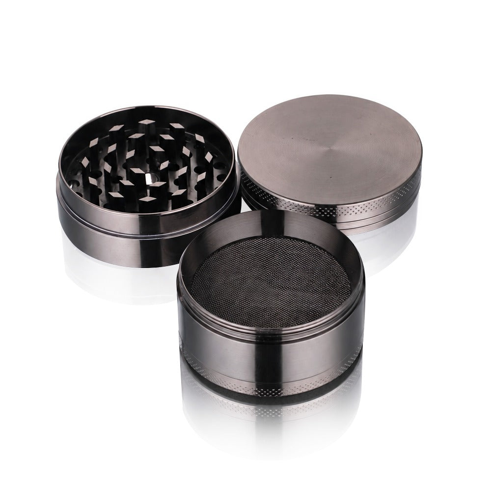 Gunmetal grey metal weed grinder from Bong Warehouse separated into its lid, grinding chamber and mesh screen section