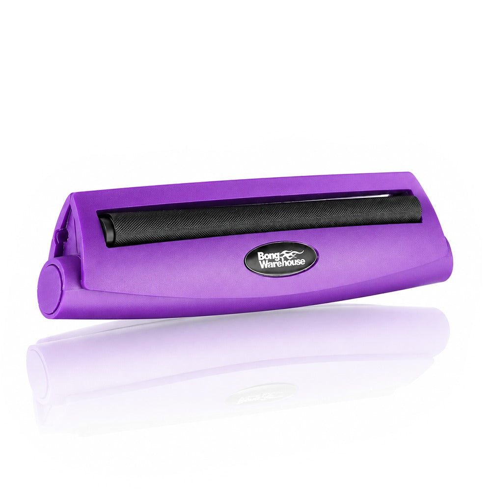 Purple king size 110mm plastic cigarette rolling machine from Bong Warehouse, low angled view of the closed machine and oval logo badge