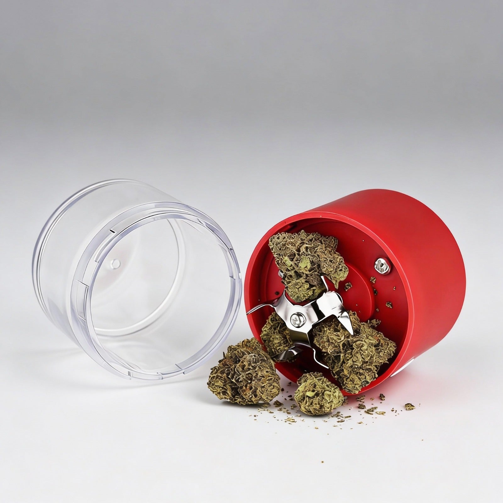 Red grinder with cannabis buds on a white background