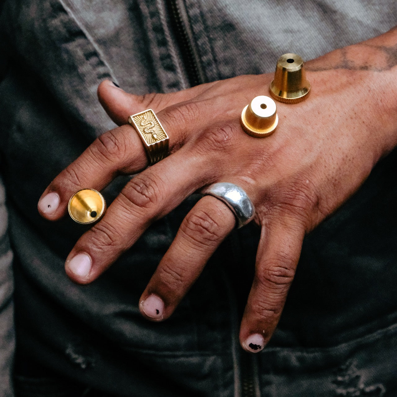 close-up of a hand with rings and three small Bong Warehousemetal cone pieces resting on the back of the hand