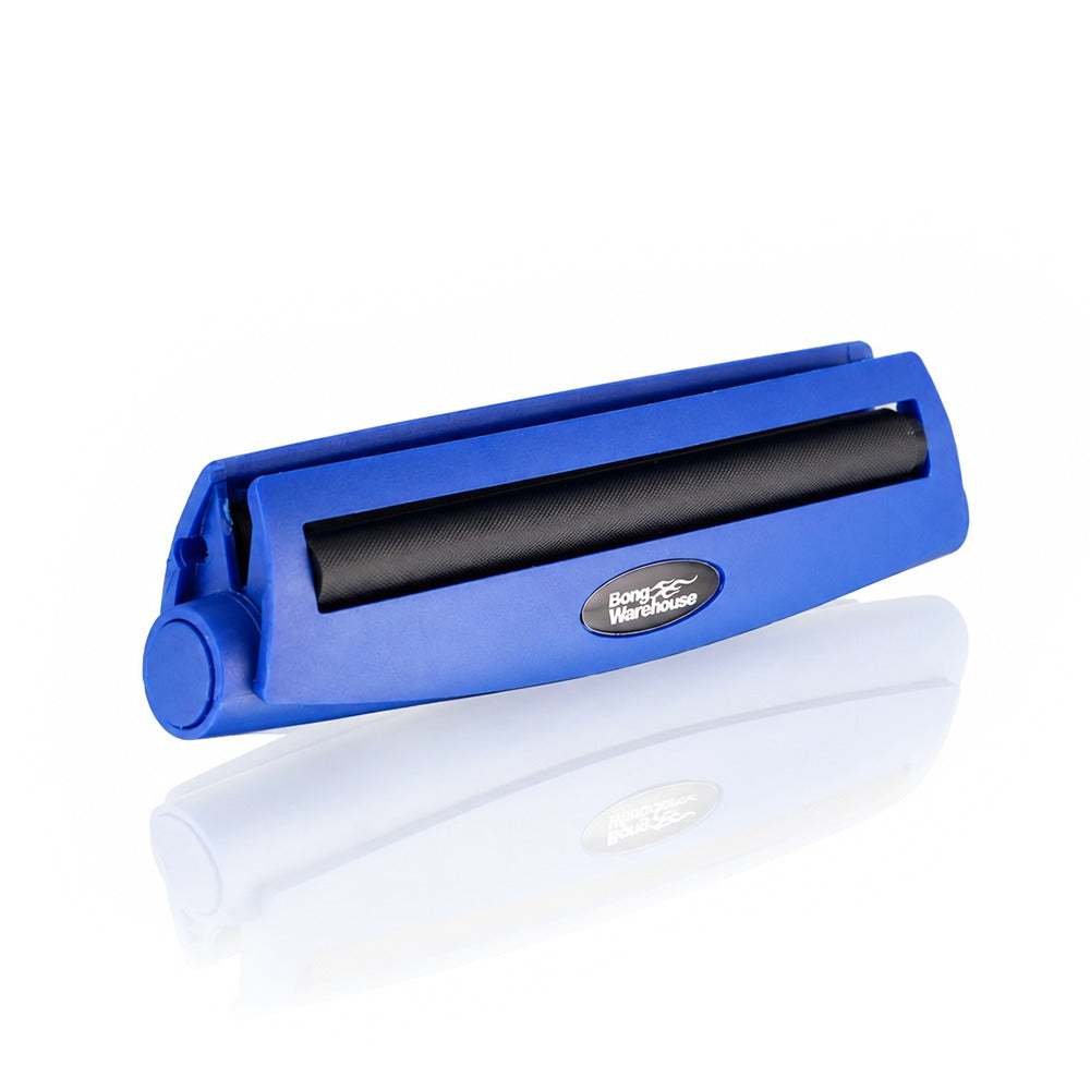 Blue king size 110mm plastic cigarette rolling machine from Bong Warehouse, angled view showing the black rolling apron and logo badge