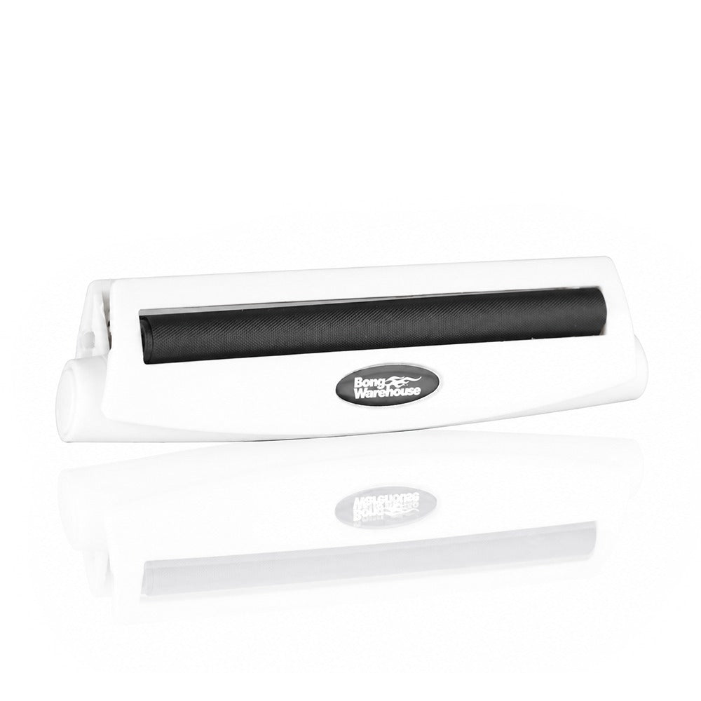 White king size 110mm plastic cigarette rolling machine from Bong Warehouse, angled view showing the black rolling apron and logo badge