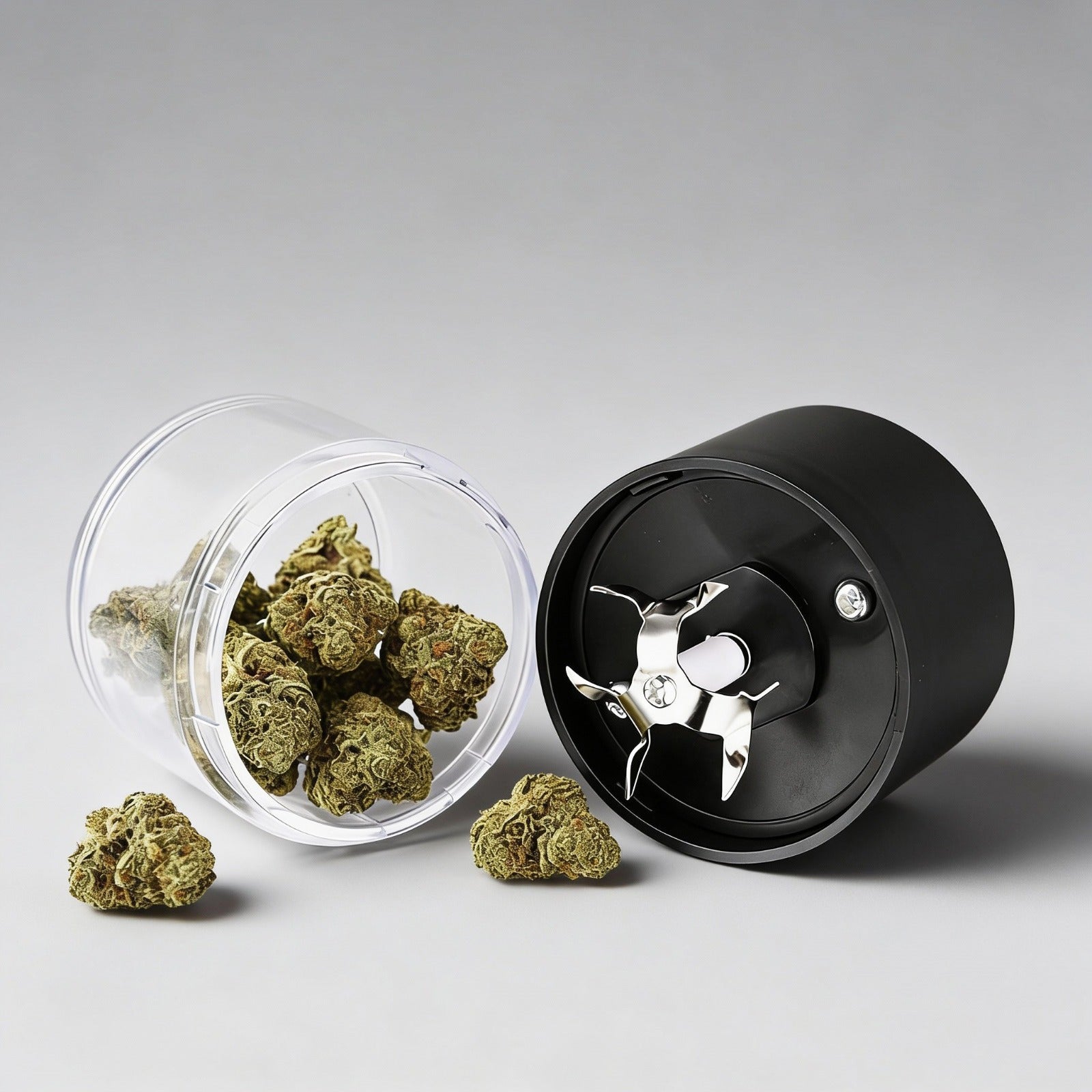 Black herb grinder with cannabis buds on a gray background