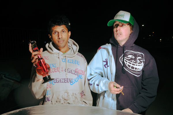 Holding a Bong Warehouse Double Chamber 30cm Glass Bong – Pink Cherry Bomb and a joint