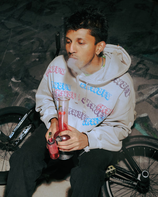Seated stoner smoking from Bong Warehouse Double Chamber 30cm Glass Bong – Pink Cherry Bomb
