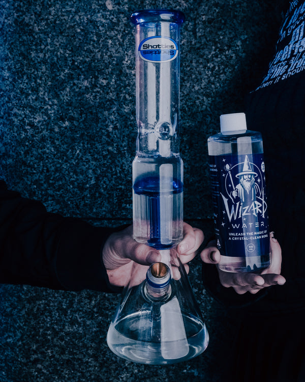 Shotties™ 33 cm Glass Perc Pillar Bong in clear and blue glass from Bong Warehouse, filled with Wizard Water