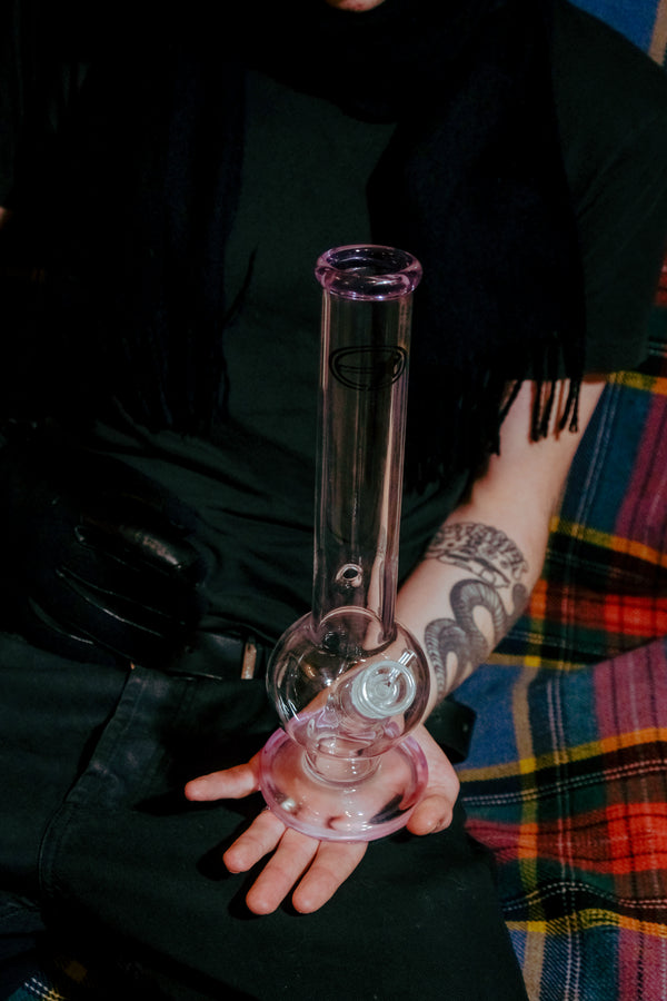 Shotties™ 33 cm Glass Bent Bubble Bong in clear and pink glass from Bong Warehouse, on a man's palm