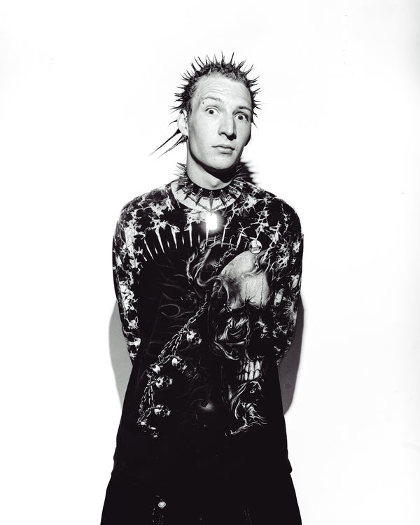 Black-and-white portrait of a man, with a Bong Warehouse Mini Beaker Bong behind him