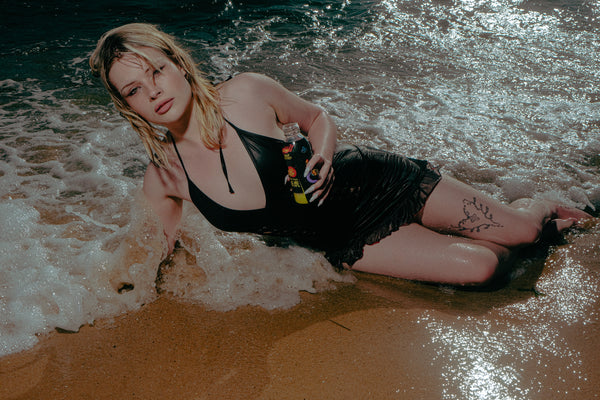 Woman lying on beach enjoying Bong Warehouse Black High Tiger 17.5cm Bottle Bong