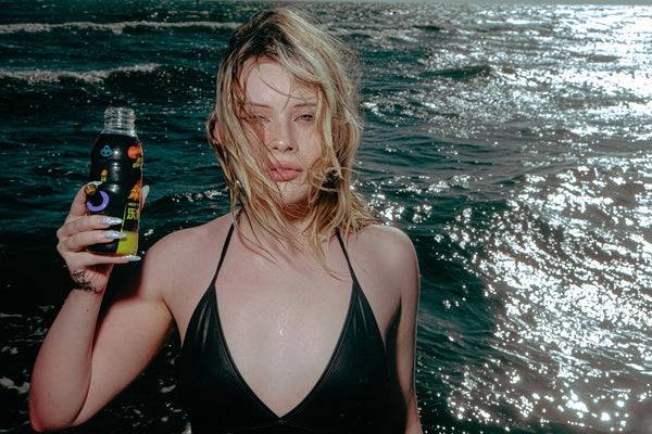 Woman holding Bong Warehouse Black High Tiger Mini Bottle 17.5cm in Black showing its metal cone piece