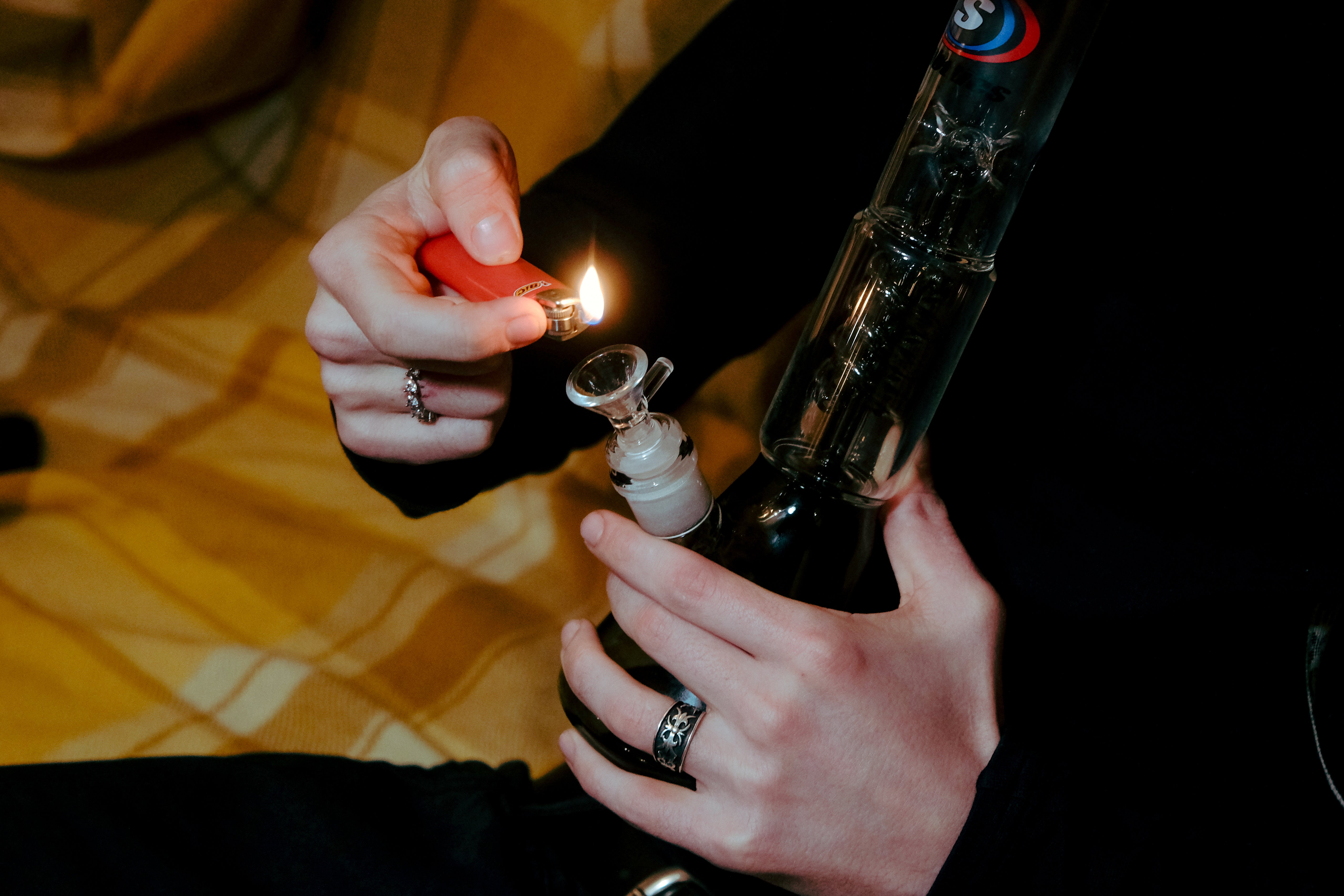 Lighting the glass bowl of a Shotties™ 30 cm Spiral Perk Glass Beaker Bong in clear and smokey glass from Bong Warehouse